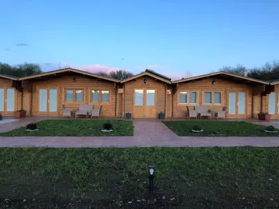 a log home with a patio in front of it at Apartamentos Playa Frejulfe in Paderne