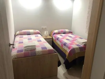 two twin beds in a small room with at Apartamentos Playa Frejulfe in Paderne