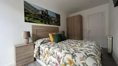 a bedroom with a bed with a floral comforter at Apartamento nuevo casco antiguo in Ponferrada