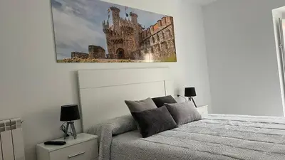 a bedroom with a bed and a picture of a castle at Apartamento nuevo casco antiguo in Ponferrada