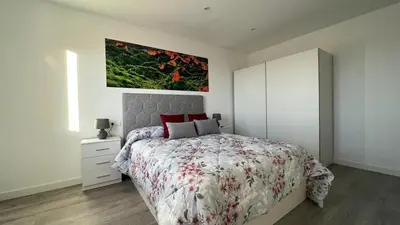 a bedroom with a bed and a painting on the wall at Apartamento nuevo casco antiguo in Ponferrada