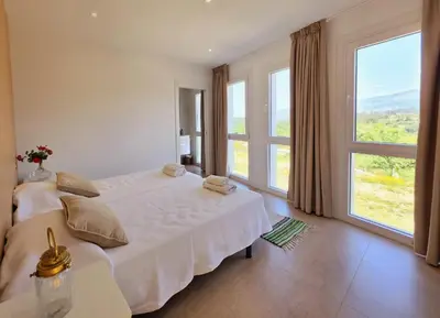 a bedroom with a large white bed with large windows at Casa Rural Abreu Do Louro in Arbo