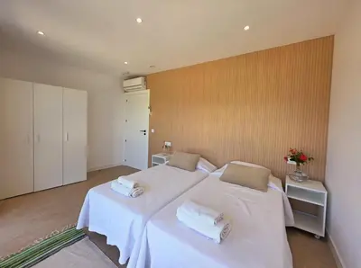 a bedroom with two beds with white sheets and towels at Casa Rural Abreu Do Louro in Arbo