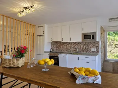 a kitchen with a table with a bowl of fruit on it at Casa Rural Abreu Do Louro in Arbo