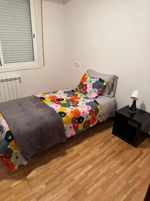 a bed with a colorful comforter in a room at casa habana in Carballino