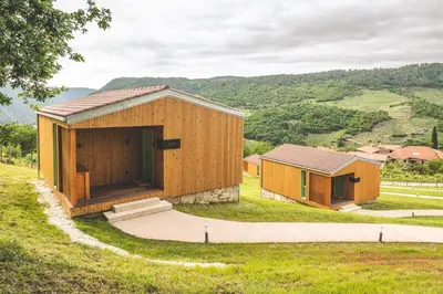 two small wooden buildings on a grassy hill at Cabañas Ribeira Sacra in Parada del Sil
