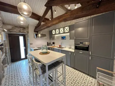 a kitchen with gray cabinets and a white table at Casa Camu in Covelo