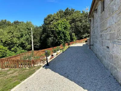 a stone wall with a fence and some plants at Casa Camu in Covelo