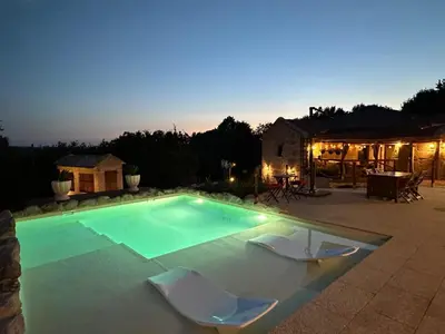 a swimming pool with two chairs and a table at Casa Camu in Covelo