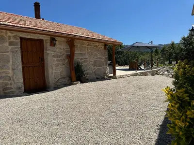 a building with a door and a gravel driveway at Casa Camu in Covelo