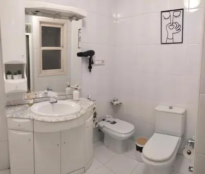 a white bathroom with a toilet and a sink at Piso Bonhome in Ourense