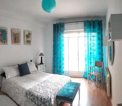 a bedroom with a bed and a window with blue curtains at Piso Bonhome in Ourense