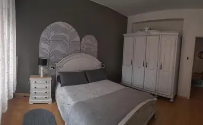 a bedroom with a white bed and a dresser at Piso Bonhome in Ourense