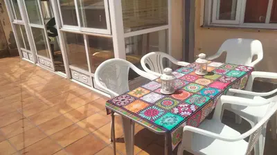 a table with white chairs and a colorful table cloth at Piso Bonhome in Ourense