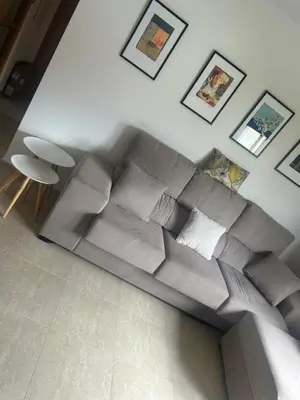 a gray couch in a living room with pictures on the wall at Recuncho do Susiño in Foz