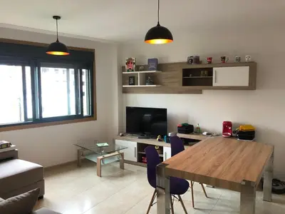 a living room with a wooden table and a television at Recuncho do Susiño in Foz