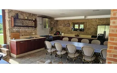 a kitchen with a table and chairs and a sink at O canto do grilo in Valeije