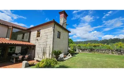a house with a yard with a stone wall at O canto do grilo in Valeije