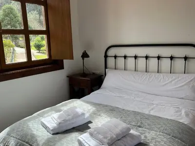 a bedroom with a bed with two towels on it at O canto do grilo in Valeije