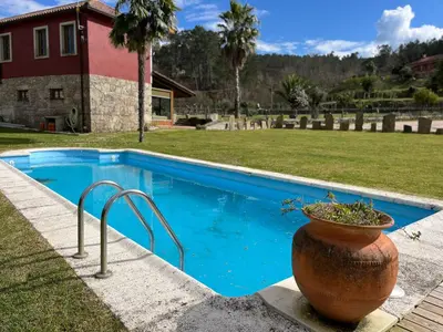 a blue swimming pool with a planter next to a house at O canto do grilo in Valeije