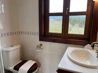 a bathroom with a toilet and a sink and a window at O canto do grilo in Valeije