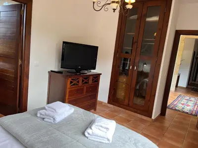 a bedroom with a bed and a flat screen tv at O canto do grilo in Valeije