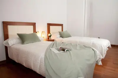 two beds with a book sitting on top of them at Silleda Via da Plata in Silleda