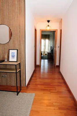 a hallway with a wooden floor and a table with a mirror at Silleda Via da Plata in Silleda