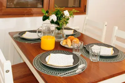 a table with plates of food and a vase of flowers at Silleda Via da Plata in Silleda