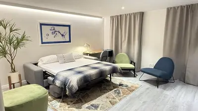 a bedroom with a bed and a table and chairs at Apartamento Ourense Vello - en el centro del casco histórico in Ourense