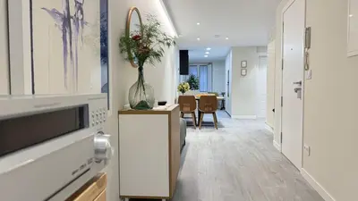 a hallway with a vase of flowers on a cabinet at Apartamento Ourense Vello - en el centro del casco histórico in Ourense