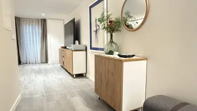 a living room with a vase on a dresser and a mirror at Apartamento Ourense Vello - en el centro del casco histórico in Ourense