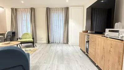 a living room with a television on a wooden cabinet at Apartamento Ourense Vello - en el centro del casco histórico in Ourense
