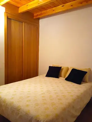a bedroom with a bed with two black pillows at A Casa da Boa Xente VUT-OU-1329 in Verín