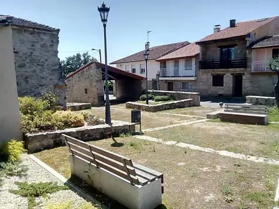a park bench in a yard with buildings at A Casa da Boa Xente VUT-OU-1329 in Verín