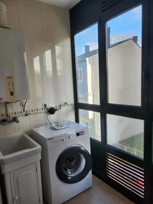 a laundry room with a washing machine and a window at CREDENCIAL Avda BECERREA in Sarria