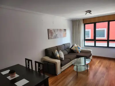 a living room with a couch and a table at CREDENCIAL Avda BECERREA in Sarria