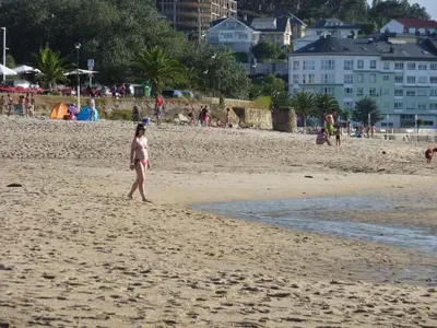 a little girl walking on the beach at Parque San Ciprián in San Ciprián
