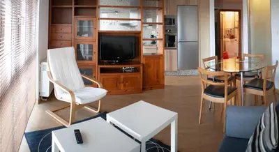 a living room with a television and a table and chairs at Parque San Ciprián in San Ciprián