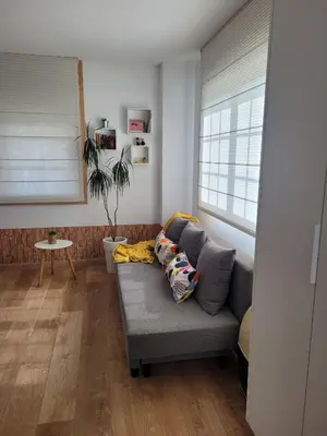 a living room with a couch with pillows on it at Besbello Suites - Estudio in Santiago de Compostela