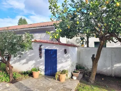 a white house with a blue door and trees at Besbello Suites - Estudio in Santiago de Compostela