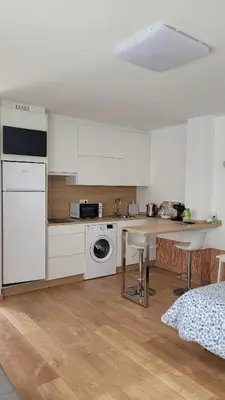 a kitchen with white cabinets and a table with chairs at Besbello Suites - Estudio in Santiago de Compostela