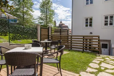 a patio with tables and chairs and a fence at Nova Compostela Apartments in Santiago de Compostela