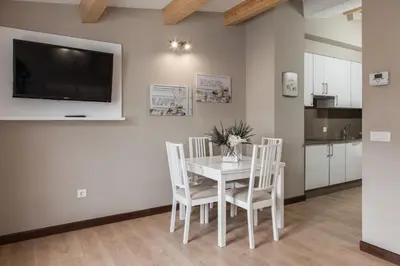a dining room with a white table and chairs at Nova Compostela Apartments in Santiago de Compostela