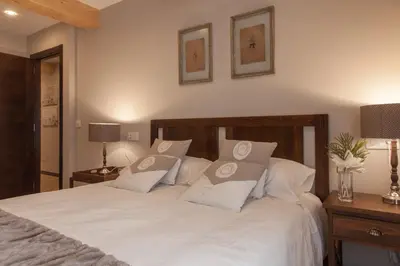 a bedroom with a white bed with white pillows at Nova Compostela Apartments in Santiago de Compostela