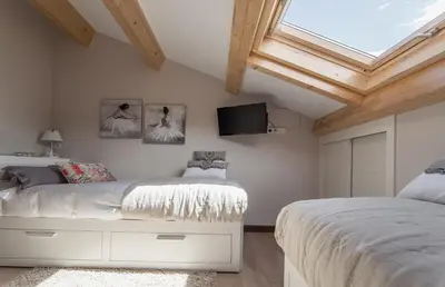 a bedroom with two beds and a skylight at Nova Compostela Apartments in Santiago de Compostela