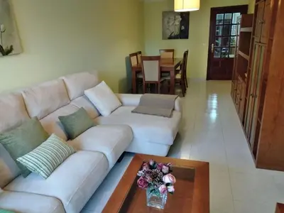 a living room with a white couch and a table at Cristel in Puentecesures
