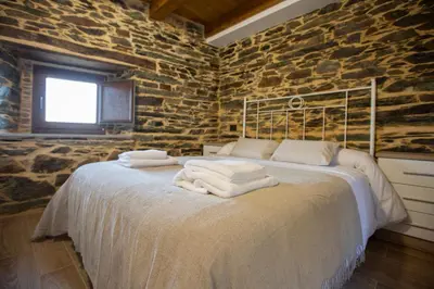 a bedroom with a bed with towels on it at Refuxio de Lamas in Becerreá