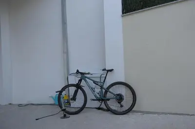 a bike is parked next to a white wall at Refuxio de Lamas in Becerreá