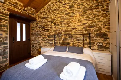 a bedroom with a bed with towels on it at Refuxio de Lamas in Becerreá